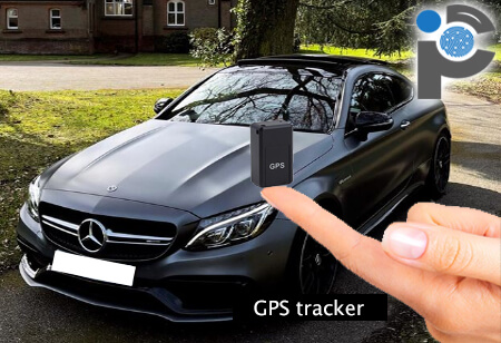 Holding a GPS tracker in front of a Mercedes car