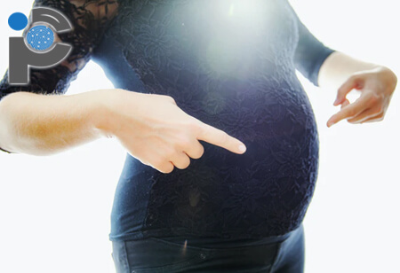 Pregnant woman pointing at her baby bump