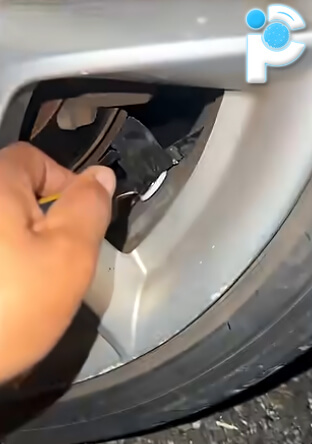 An Apple Airtag hidden on a car wheel with tape