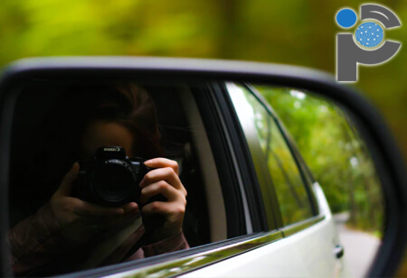 Private investigator taking photos from a car window