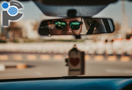 Man wearing sunglasses in a rear view mirror