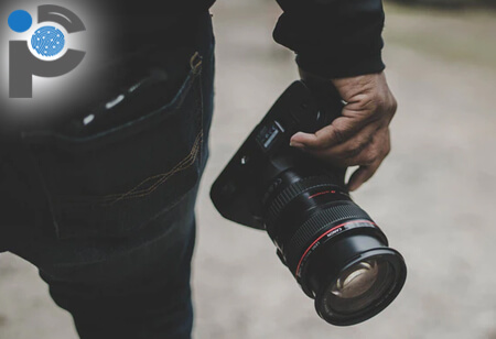 Private investigator holding a DSLR camera