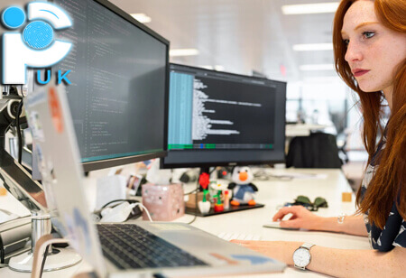 A female private investigator working at 4 computer monitors